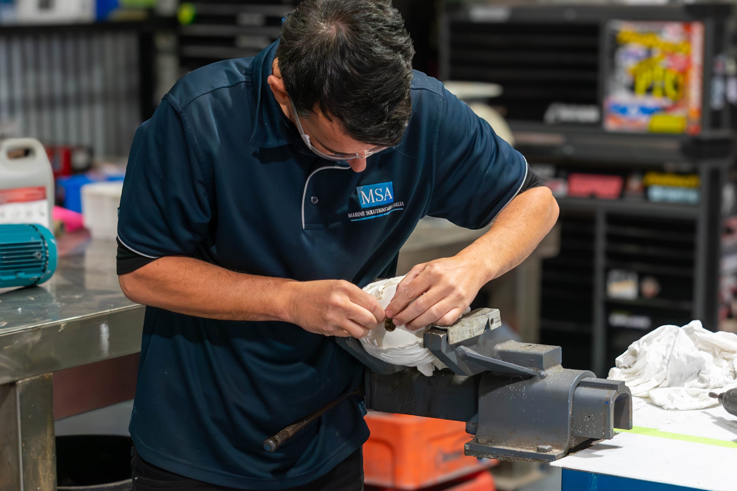 Marine Solutions Australia engineer assembling a davit component at the Coomera workshop bench