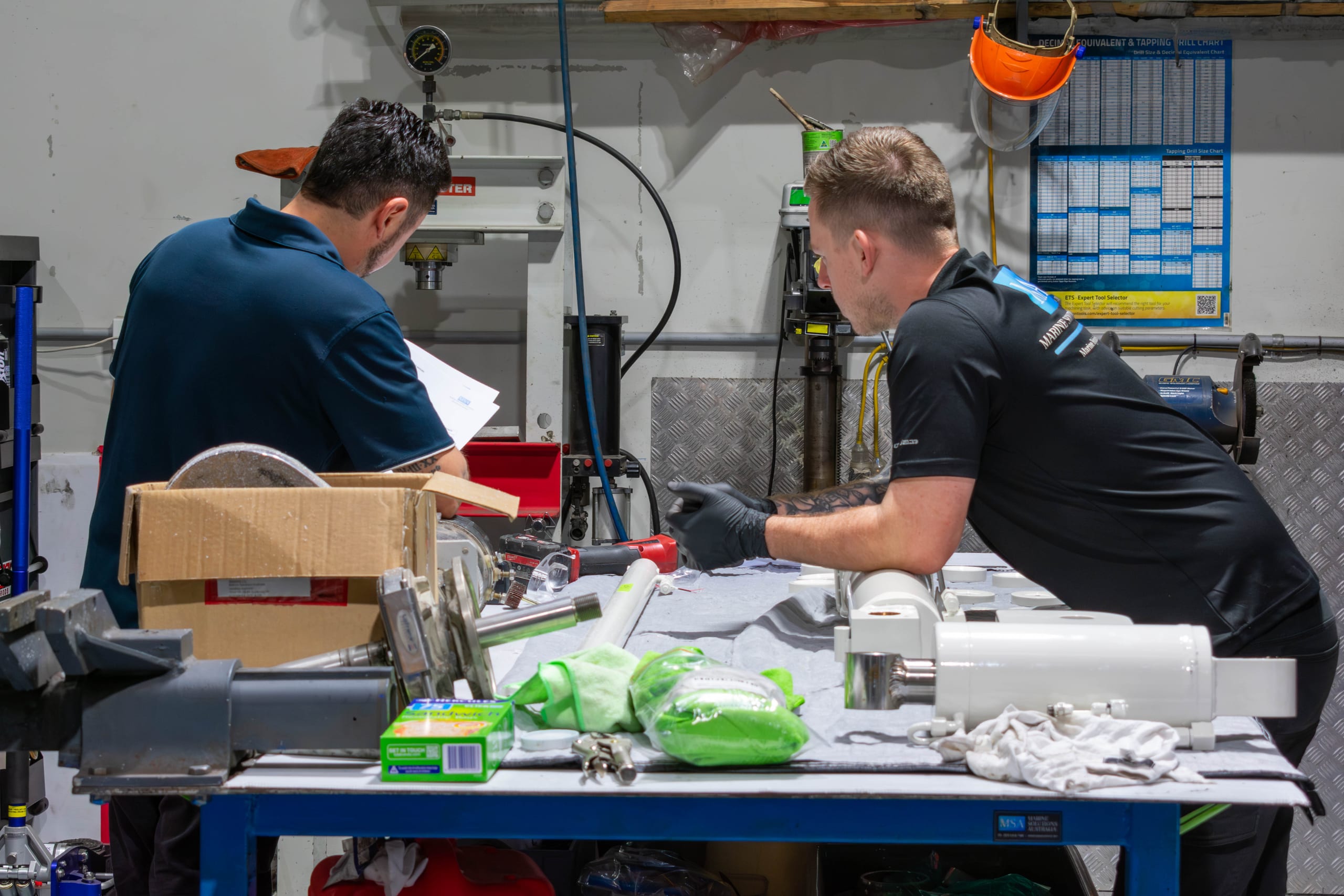 Marine Solutions technicians rebuilding disassembled davit hydraulic rams on the workshop bench