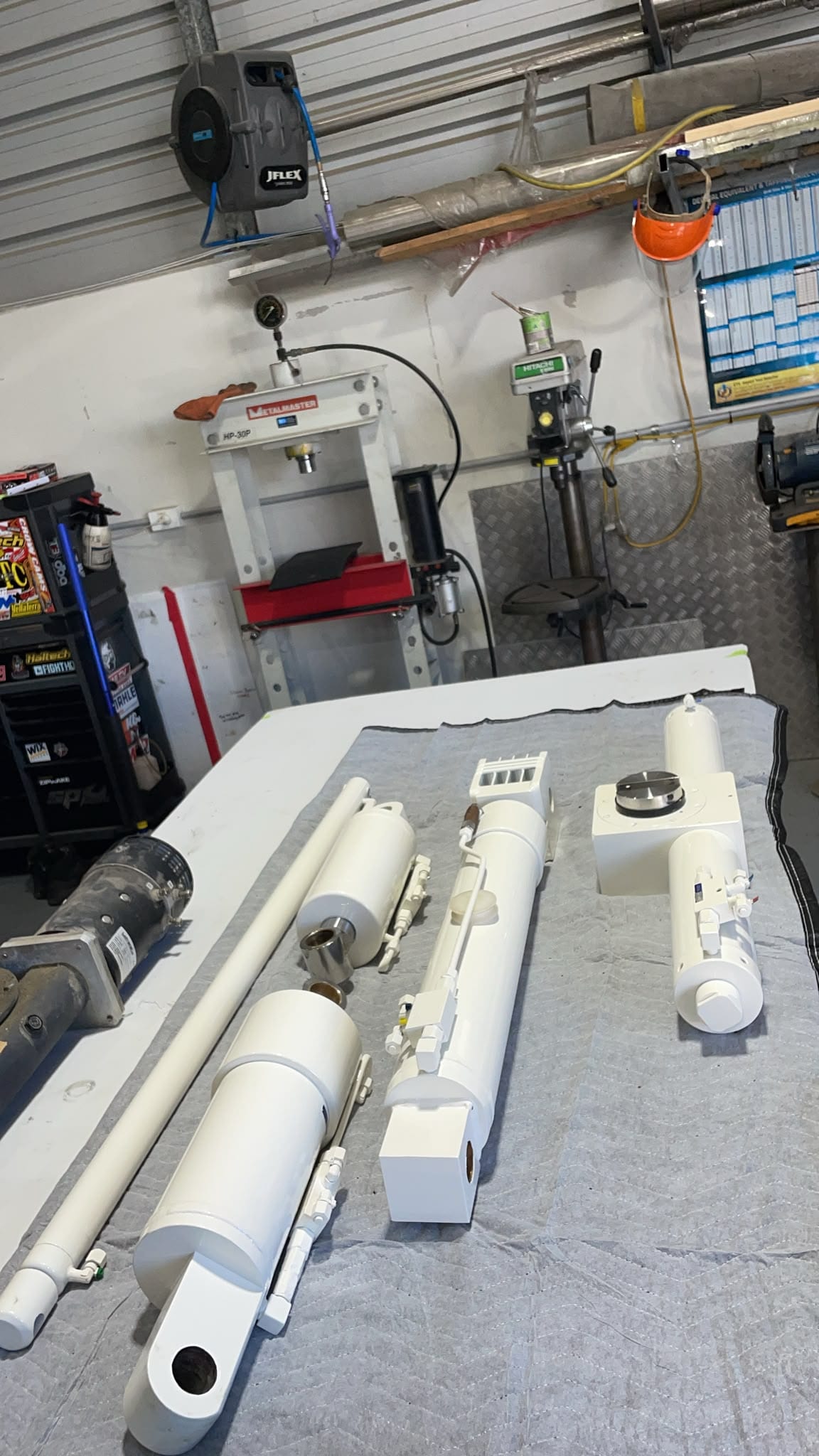 Overhauled cylinders and boom sections back in the workshop, freshly painted