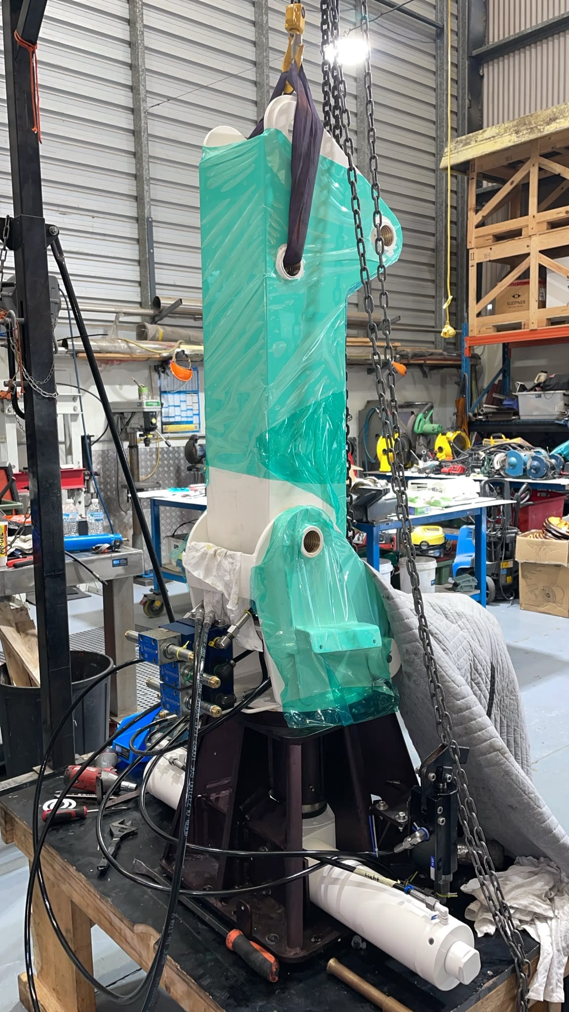 Wrapped boom slung on the chain hoist for fit-up to the pedestal