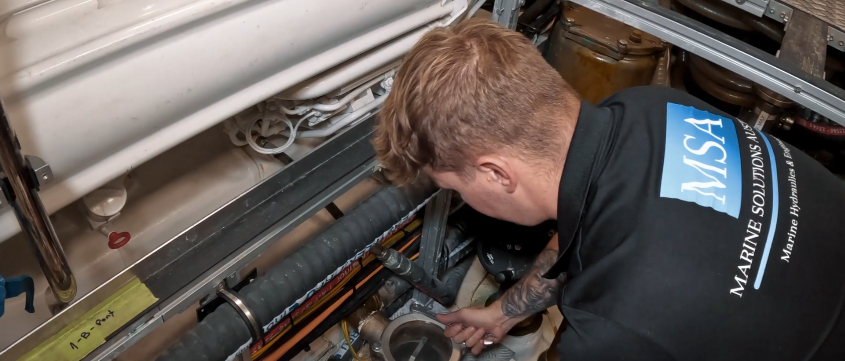 A Marine Solutions Australia technician servicing pipework and systems in a vessel's engine bay