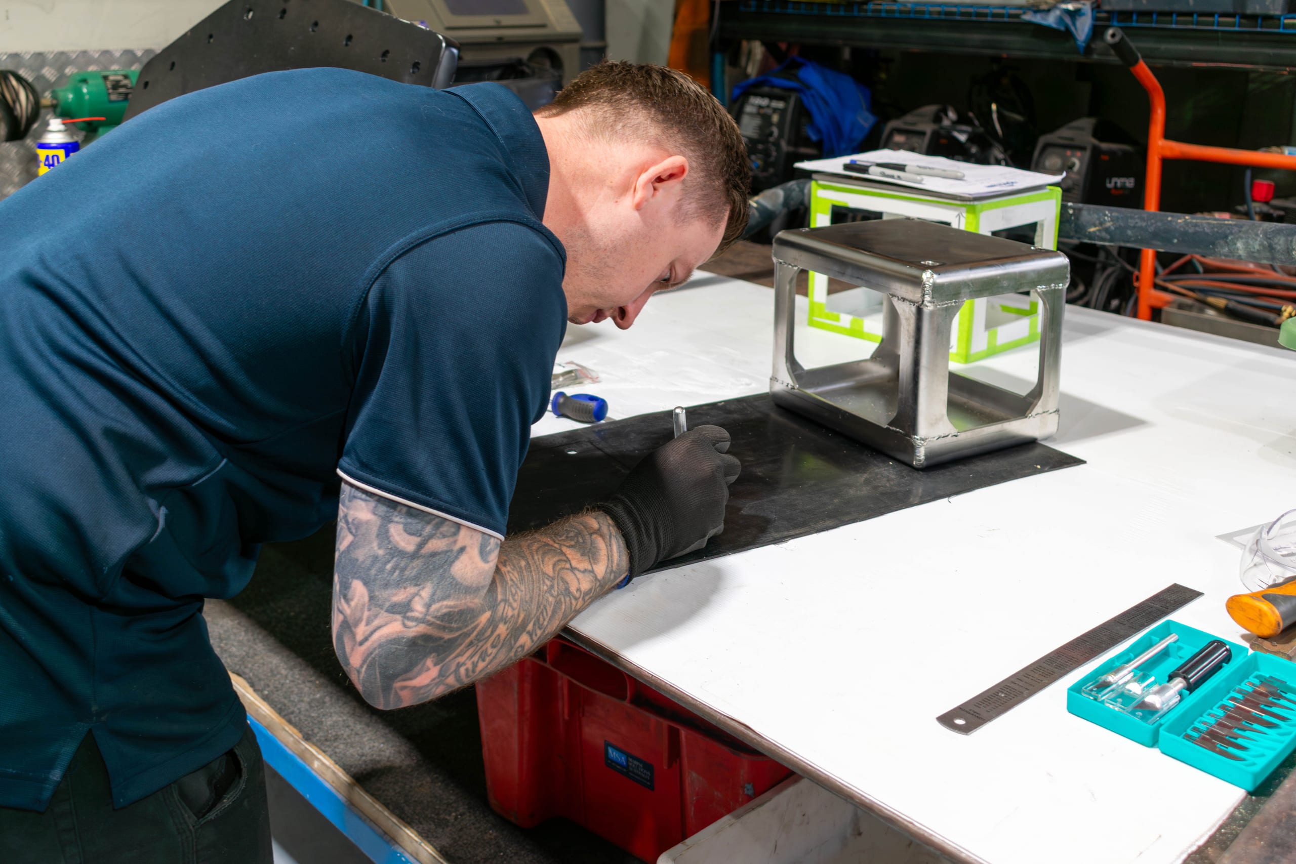 Marine Solutions Australia technician marking out a plate beside a welded stainless steel frame