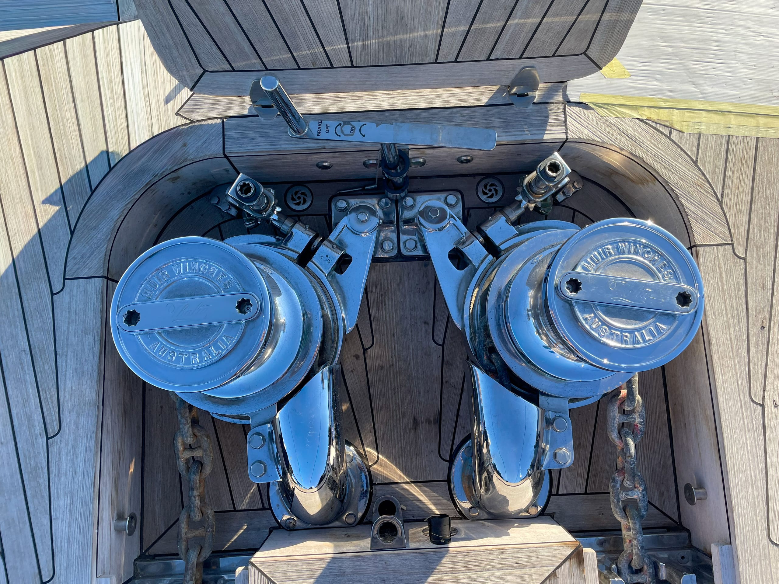 Twin Muir vertical windlasses fitted in a teak foredeck anchor well, chain led to each gypsy