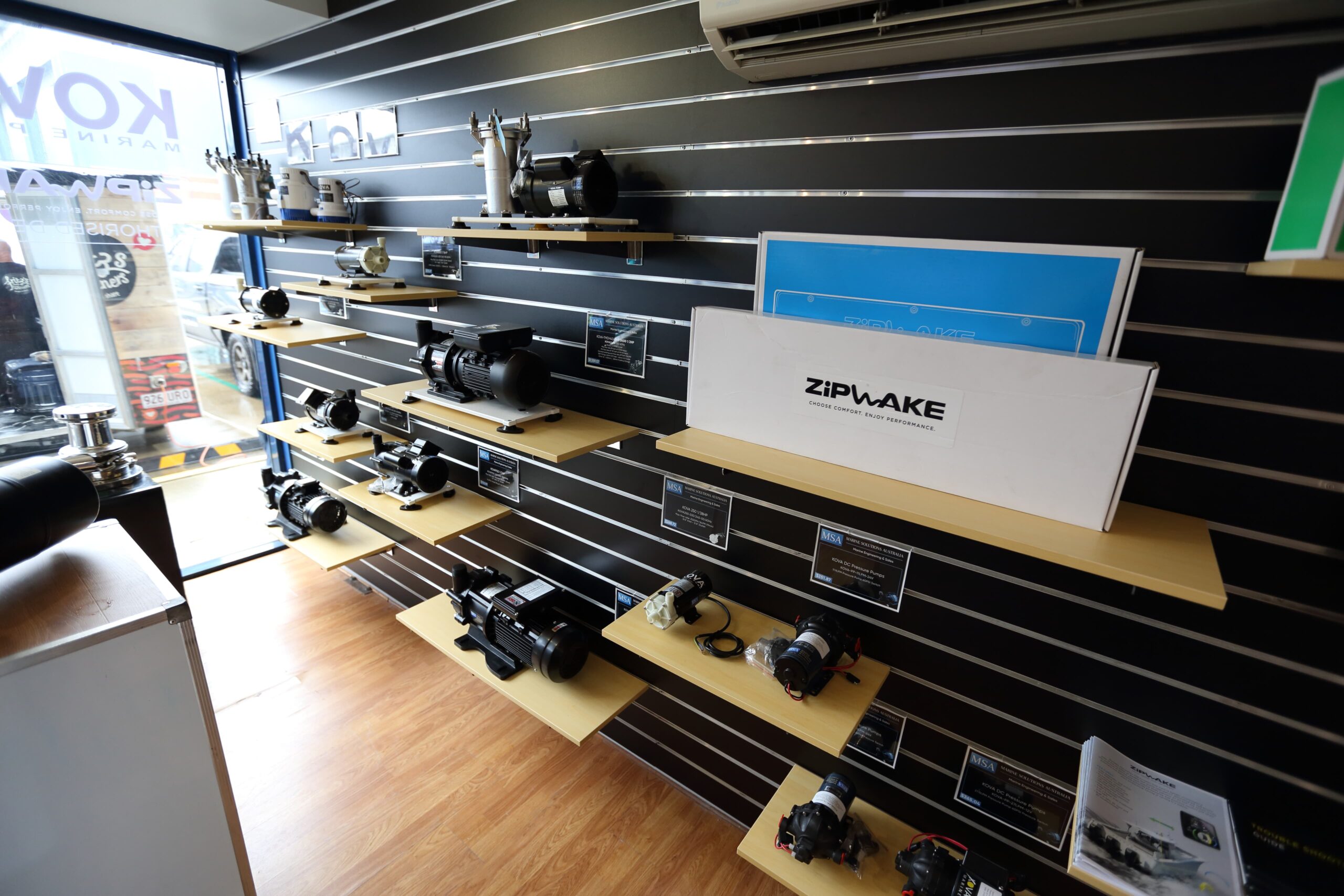 Parts and equipment on the showroom wall at Gold Coast City Marina, with a Zipwake system on the shelf
