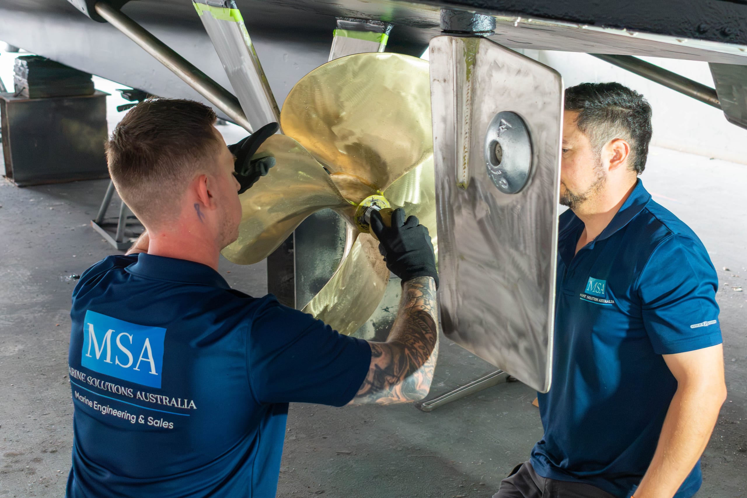 Two engineers seating the propeller on its taper