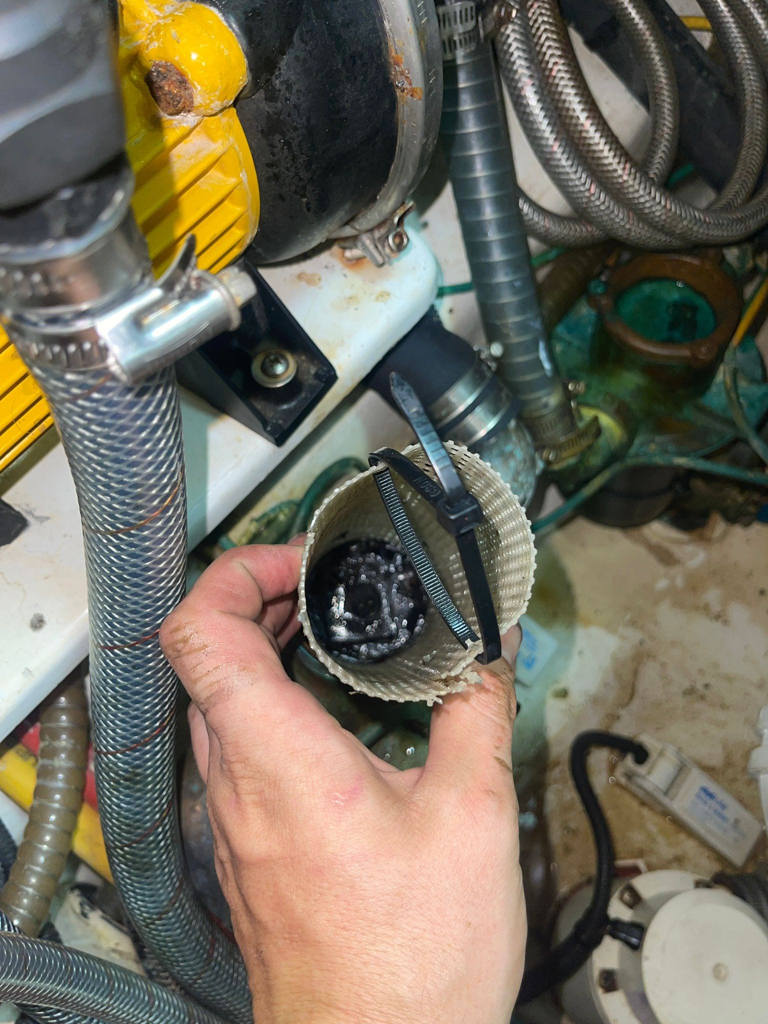 A strainer basket held together with cable ties, every handle in the set broken